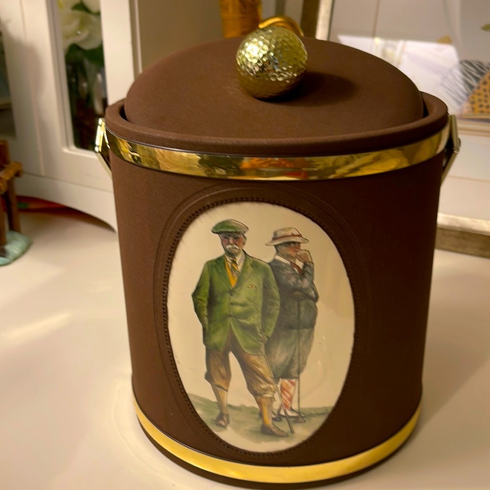 Vintage ice bucket with golf players painting and golf ball lid handle.